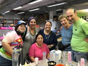 Smiling group crafting candles in workshop