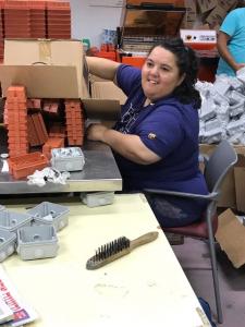 A woman sitting at a table with boxes of food.