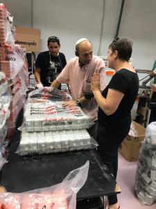 A group of people standing around some boxes.