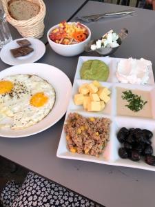A table with plates of food and bowls on it.
