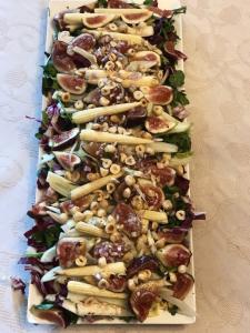 A rectangular pizza with many different toppings.