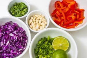 A table topped with bowls of food and lime.