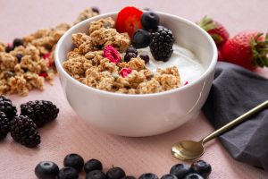A bowl of cereal with fruit and yogurt.