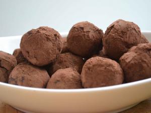 A bowl of chocolate truffles on top of a table.