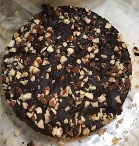 A cake with nuts and chocolate on top.