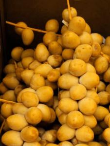 A pile of yellow fruit sitting on top of each other.