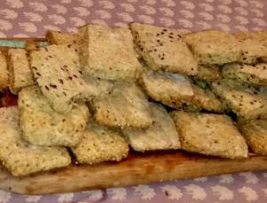 A wooden board with crackers on it