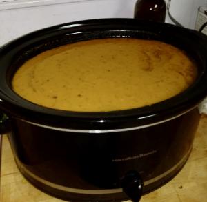 A slow cooker with some soup in it.