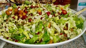 A bowl of salad with lettuce, tomatoes and other ingredients.