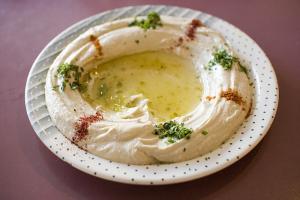 A white plate topped with hummus and vegetables.