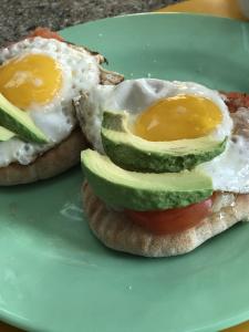 A plate of food with an egg and avocado on it.
