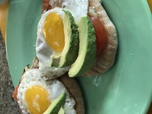 A plate of food with an egg and avocado on it.