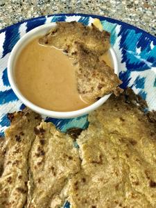 A bowl of peanut butter and some cookies on a table