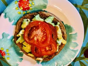Toast topped with scrambled egg, avocado, tomato