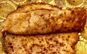 Two crispy dosas on ornate golden plate
