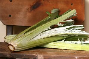 A bunch of green vegetables on top of a wooden table.