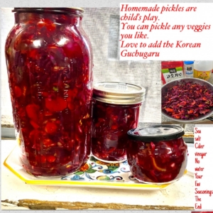 A jar of red peppers and other jars on a table.
