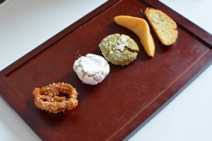 A wooden tray with different types of food on it.