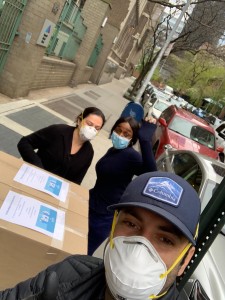 A group of people standing around boxes on the side of a road.