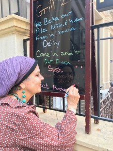A woman writing on the board outside