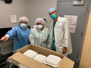 Three doctors standing in front of a box.