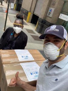 A man and woman wearing masks standing next to boxes.