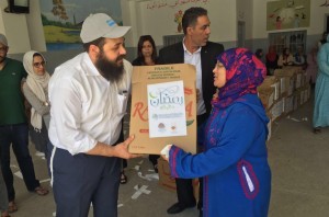 A man and woman holding a box of food.