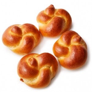 Four small buns are sitting on a table.