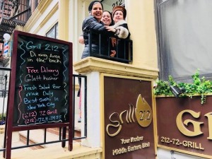 A family is sitting in the window of an eatery.