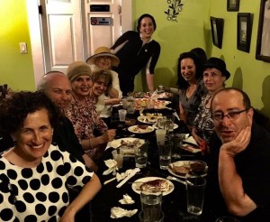 Smiling friends enjoying dinner at long table