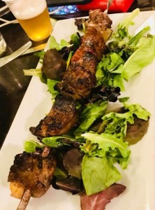 grilled meat kebab on mixed greens