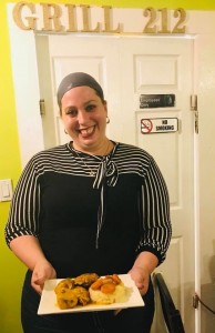 A woman standing in front of a door smiling.