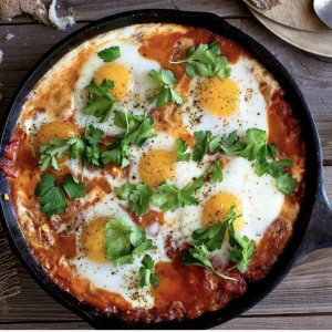 A pan of food with eggs on top.
