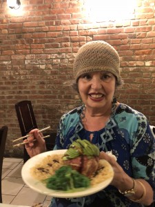 A woman sitting at a table with food.