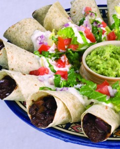 A plate of food with tortillas and guacamole.