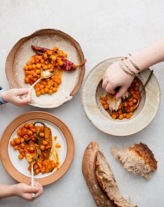 A group of people sitting around plates with food.
