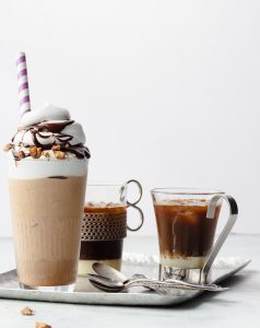 A cup of coffee and two glasses on the table.