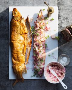 A fish and some meat on a white plate.