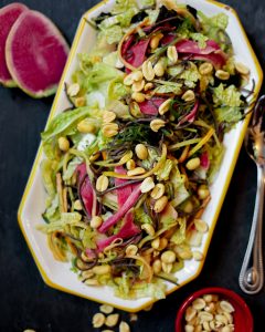 A plate of salad with corn, lettuce and beets.