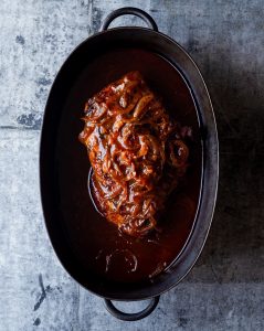 A bowl of meat with sauce on top.