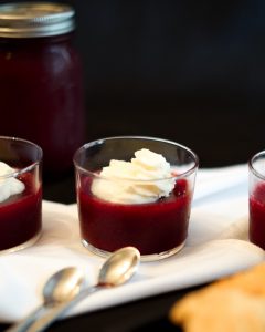 A table with three glasses of jelly and spoons.