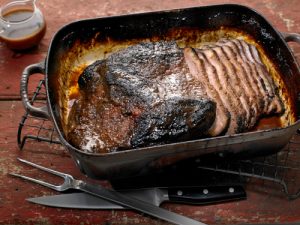 Carved roast beef with gravy in pan