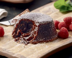 A piece of cake on top of a wooden board.
