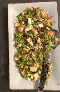 A white plate topped with broccoli and apples.