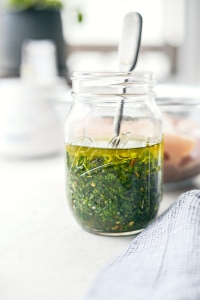 A jar of pesto sitting on top of a table.