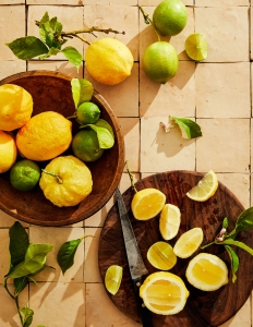 A table with two bowls of fruit and a knife.