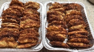 Two trays of fried food in aluminum foil.