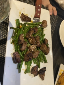 A plate of food with meat and green beans.